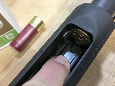 You can unload the magazine tube without cycling the action by pressing the silver locking tab visible in the upper left.