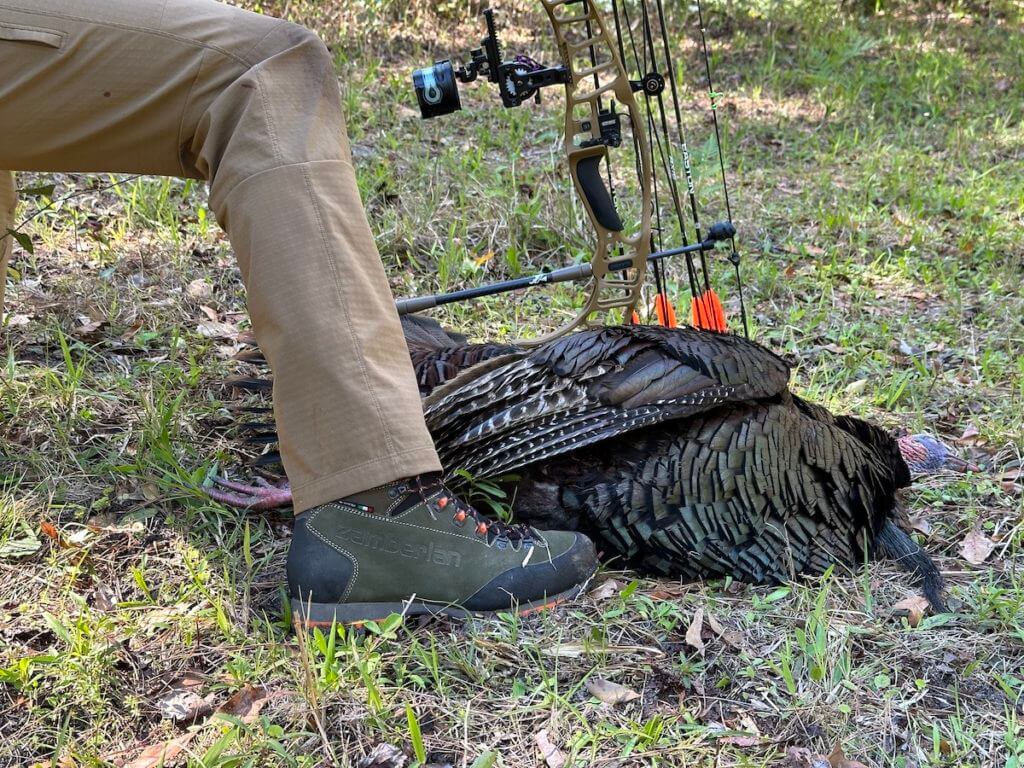 Bow hunter next to downed turkey and wearing Sitka Equinox Guard pants