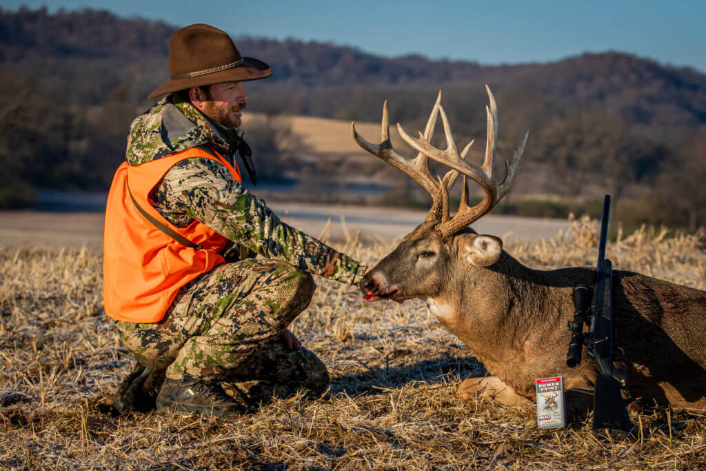 Hunter and his buck posed with bolt-action rifle and 400 Legend