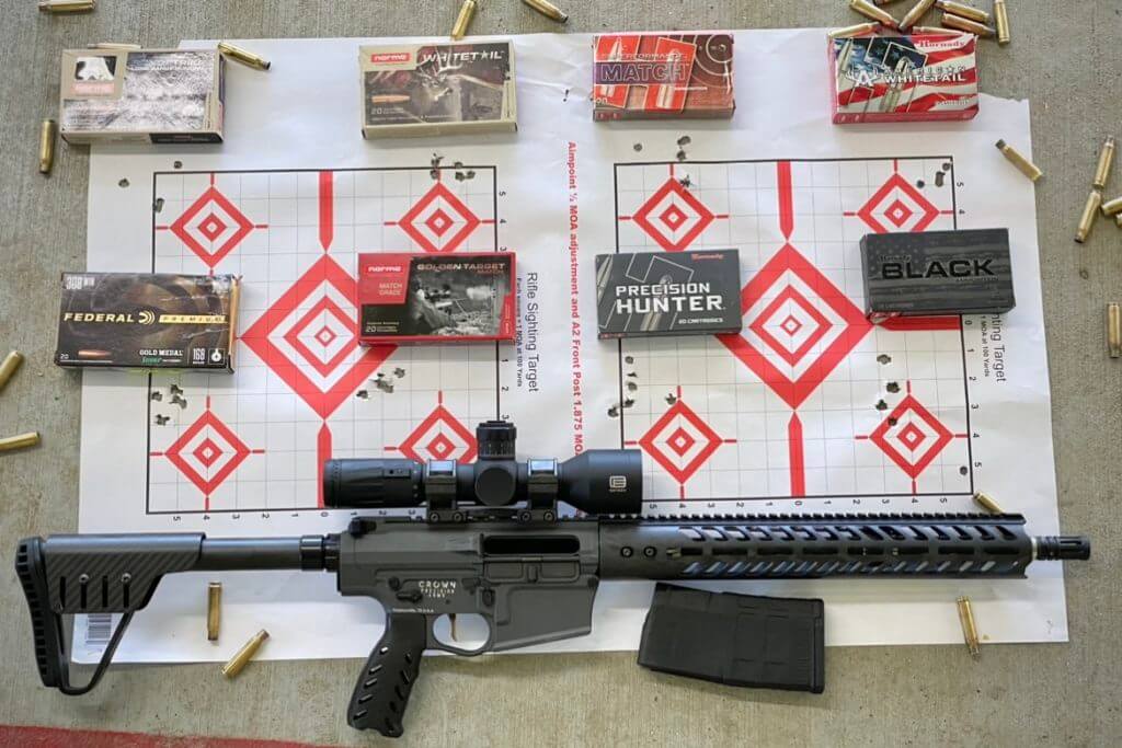 Testing the precision of the Crown Precision Elite. Boxes of ammunition are placed next to their respective groups.