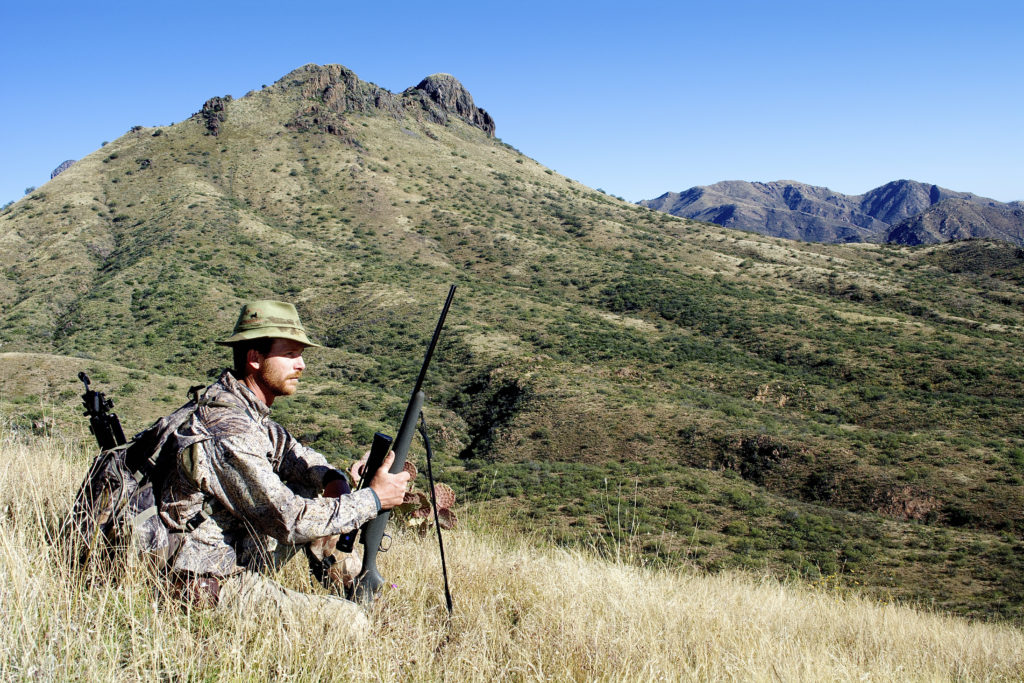 Hunter setting up for his shot in long brush